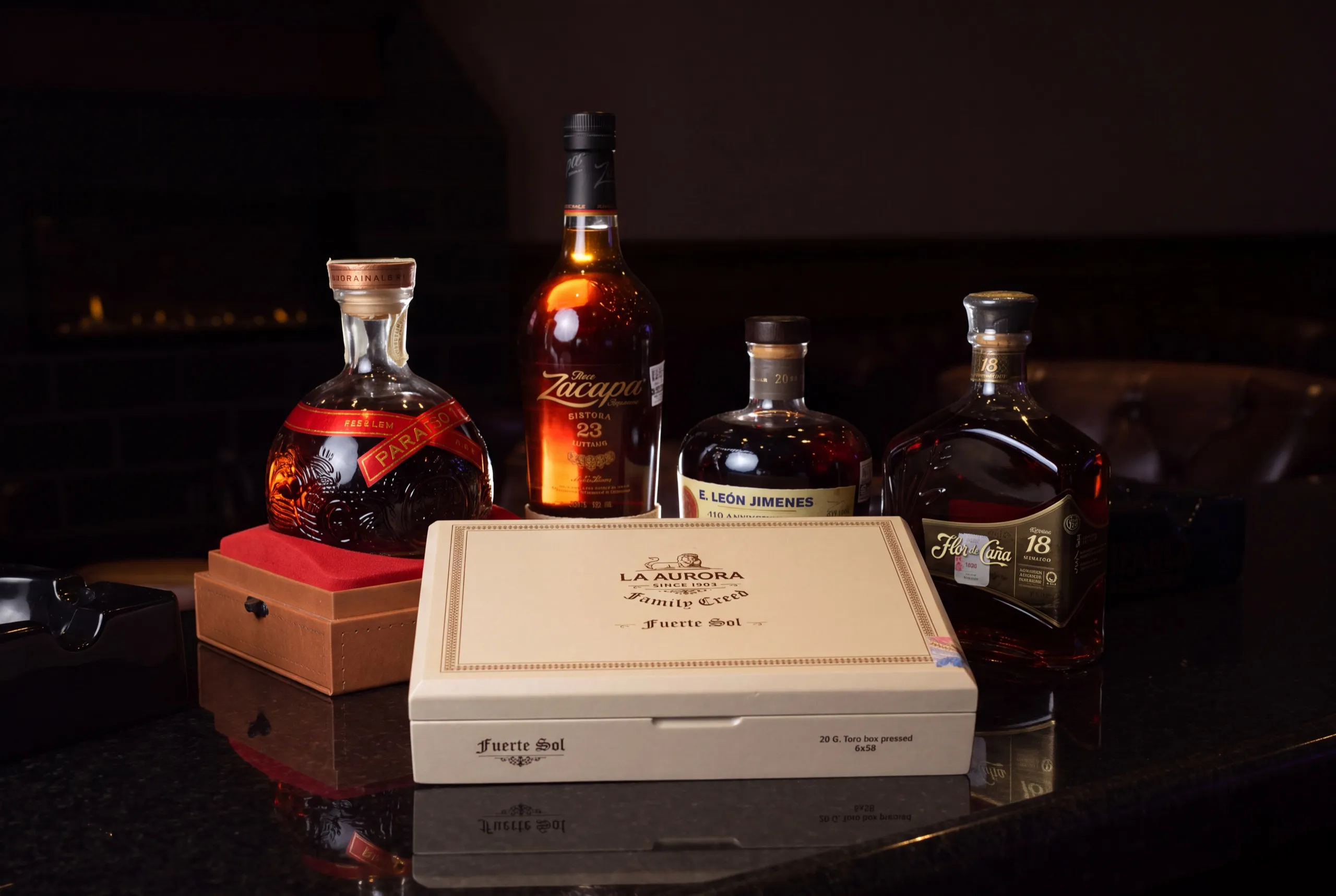 A La Aurora cigar box and a flight of four aged rums on the bar at Henry's